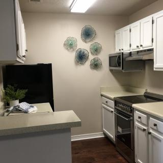 A compact kitchen with white cabinets and modern appliances.