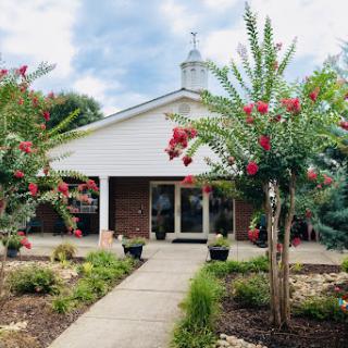 A charming entrance adorned with vibrant flowers leading to a welcoming building.