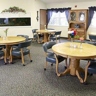 A cozy dining space with round tables and cushioned chairs.