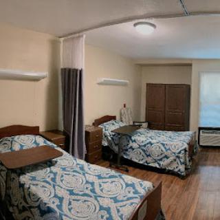 A cozy shared bedroom featuring two beds, each adorned with patterned bedding and a warm wooden aesthetic.