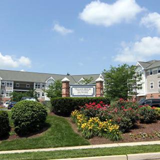 A beautifully landscaped area in front of a large residential building.