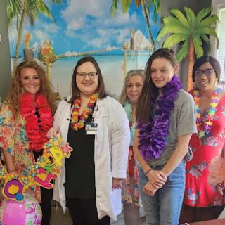 A cheerful gathering of healthcare professionals celebrating with a tropical theme.