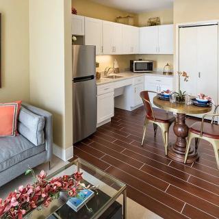 A modern apartment with an open floor plan, featuring a cozy living room, dining area, and kitchen.