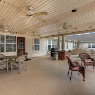 A spacious covered patio with outdoor seating and ceiling fans.