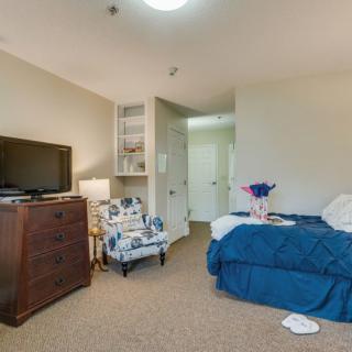 A cozy bedroom interior with a bed, television, and comfortable seating.