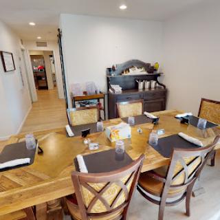 A spacious and elegantly arranged dining room with a wooden table and stylish chairs.