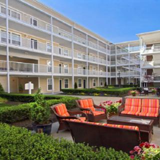 A well-maintained apartment complex with a cozy outdoor seating area in the courtyard.