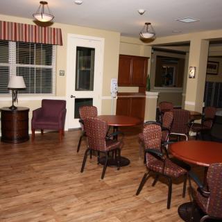 A cozy lounge area with tables and chairs on a hardwood floor.