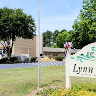 A welcoming view of the Lynn facility, featuring lush greenery and a prominent sign.