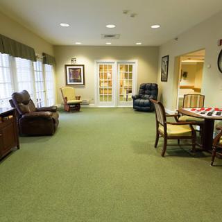 A spacious living room with comfortable seating, carpeted flooring, and tasteful decor.