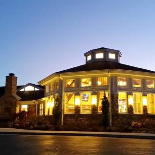 A well-lit building with large windows during the evening.