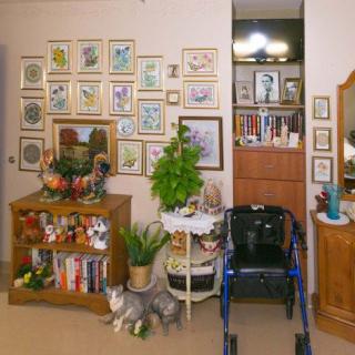 A cozy living room with wall art, a bookshelf, and a walker.