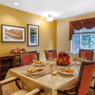 A cozy dining room with an autumn-themed table setting and warm decor.