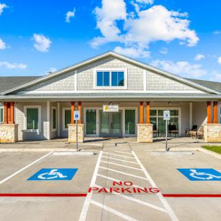A modern building featuring designated handicap parking and clear signage.