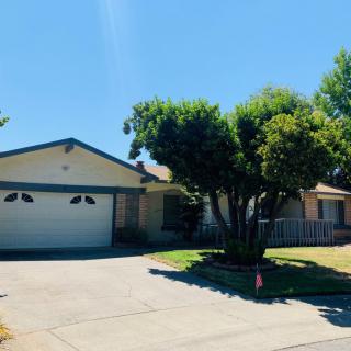 A sunny suburban house with a driveway and garage.