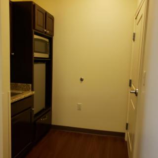 A small kitchen area with built-in appliances and dark wood cabinets.