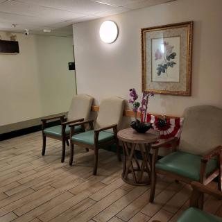 A cozy waiting area with chairs, a table, and artwork on the wall.