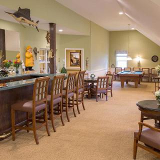 A cozy interior with a bar and seating area, featuring warm lighting and elegant decor.