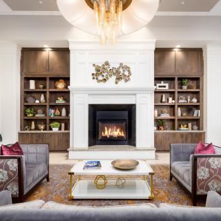 A modern living room featuring a cozy fireplace, elegant bookshelves, and stylish furniture.
