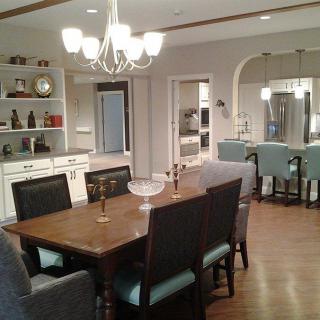 A modern open-concept dining area with elegant furnishings and a view into the kitchen.