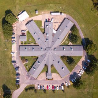 Aerial view of a unique architectural facility surrounded by greenery.