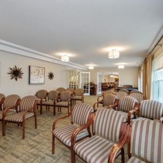 A well-lit waiting or meeting room with rows of striped chairs arranged neatly.
