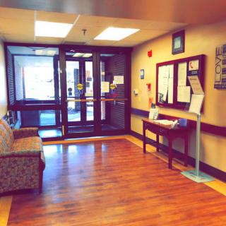 A cozy lobby area with a couch and informational displays near the entrance.