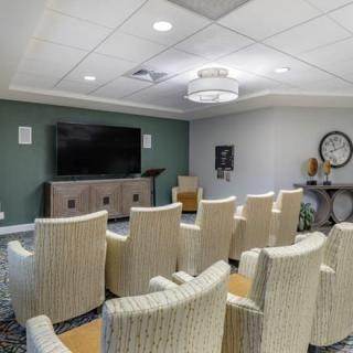 A well-organized conference room with rows of chairs facing a large television.