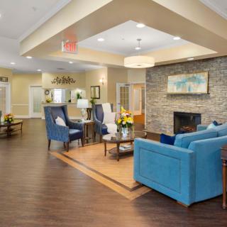 A modern and comfortable living room interior with a blue sofa, fireplace, and elegant decor.