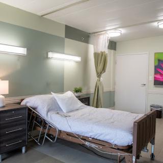 A modern and clean hospital room featuring a hospital bed, bedside table, and calming decor.
