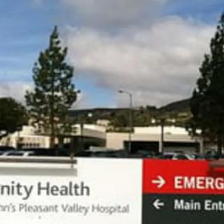 Signage outside a hospital indicating directions to the emergency and main entrance.