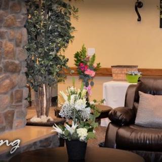 A cozy living room interior with elegant flower arrangements and a comfortable leather chair.