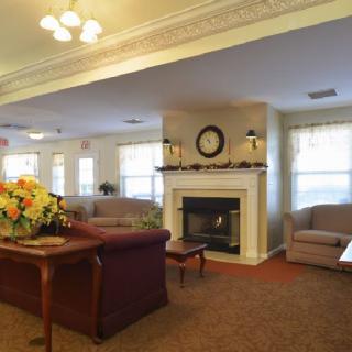 A cozy living room with a central fireplace and comfortable seating.