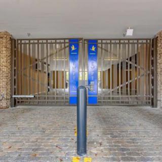 A secured metal gate at the entrance of a parking garage.