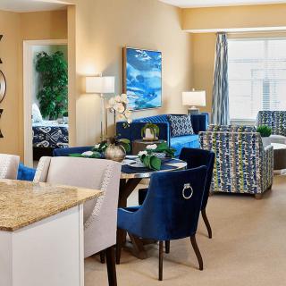 A stylish open-concept living and dining area featuring modern furniture and vibrant blue accents.