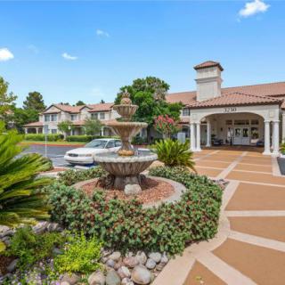 A beautifully landscaped residential area featuring a fountain and stylish architecture.