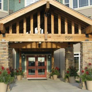 A building entrance with wooden beams and decorative plants.