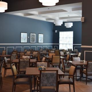 A spacious dining area featuring modern furniture and blue walls, ready to welcome guests.