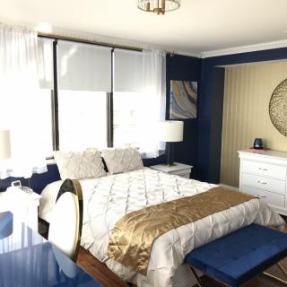 A modern bedroom with blue accents and ample natural light.