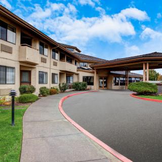 A hotel with a covered entrance and a circular driveway.