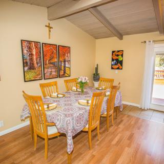 A cozy dining room with a set table and colorful artwork on the walls.