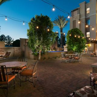 Cozy outdoor patio area with string lights and seating at dusk.