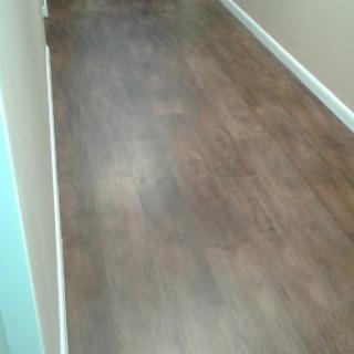 A view of a hallway with wooden flooring.