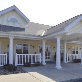 A residential house with a covered porch and prominent columns.