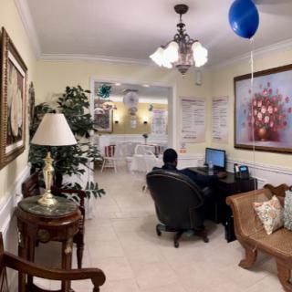 A cozy office space with a desk, computer, and decorative elements including artwork and a blue balloon.