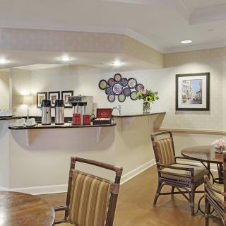 A cozy cafe interior with a seating area and a coffee station.