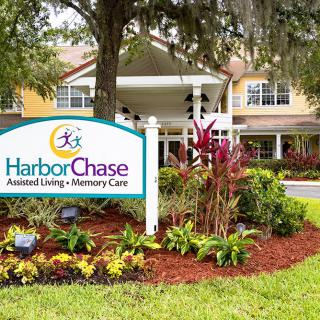 Exterior view of HarborChase Assisted Living with a landscaped garden and prominent signage.