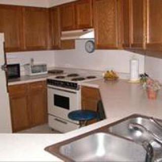A compact kitchen with wooden cabinets and standard appliances.
