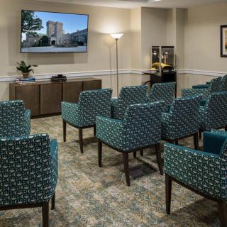 A small meeting room with arranged seating facing a television.