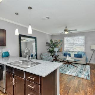 A modern open floor plan shares a sleek kitchen and cozy living area with stylish decor.